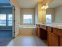 Bathroom with a soaking tub, and cherry-stained wood vanity at 275 Autry Mill Ln, Suwanee, GA 30024