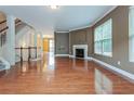 Open living room features hardwood floors, a fireplace, and large windows for natural light at 275 Autry Mill Ln, Suwanee, GA 30024