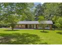 Classic brick single-story house with a cozy covered porch and an expansive green lawn at 676 Smith Store Rd, Covington, GA 30016