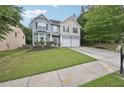Attractive two-story home with a two-car garage, manicured lawn, and mature trees at 7530 Springbox Dr, Fairburn, GA 30213
