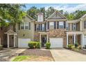 Two-story brick and vinyl townhome featuring a one-car garage and beautifully maintained landscaping at 3335 Thornbridge Dr, Powder Springs, GA 30127