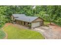 Beautiful two-story home with a garage surrounded by mature trees and lush green lawn at 5632 Stillwater Ct, Stone Mountain, GA 30087