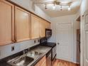 Compact kitchen featuring stainless appliances, granite countertops and light wood cabinetry at 1150 Collier Nw Rd # 10L, Atlanta, GA 30318
