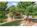 Exterior view of home featuring a covered porch, stone accents, and landscaping, nestled among mature trees at 238 Balsam Dr, Canton, GA 30114