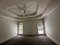 Spacious bedroom featuring a tray ceiling, neutral paint, and two bright windows with natural light at 2612 Peterboro Row, Marietta, GA 30062
