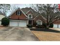 All brick home with an attached two car garage and beautifully manicured yard with mature trees at 2612 Peterboro Row, Marietta, GA 30062