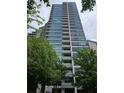 Modern high-rise building featuring multiple balconies and floor-to-ceiling windows surrounded by mature trees at 700 Park Regency Ne Pl # 805, Atlanta, GA 30326