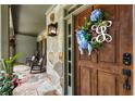 Charming front porch with rocking chairs and stone details leading to a decorative wooden front door at 10530 Tuxford Dr, Alpharetta, GA 30022