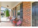 Comfortable front porch with wicker seating, brick detailing, and a view of the front yard and driveway at 456 Rockford Sw Pass, Marietta, GA 30064