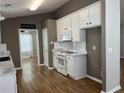 Bright kitchen featuring white cabinets, stainless appliances, and stylish wood-look flooring at 804 Village Pl, Loganville, GA 30052