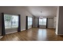 Spacious living room featuring wood floors and lots of natural light through many windows at 804 Village Pl, Loganville, GA 30052