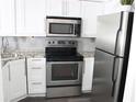 Well-lit kitchen features stainless steel appliances, white cabinetry and tile backsplash at 2870 Pharr Court South Nw # 2507, Atlanta, GA 30305