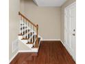 Inviting entryway featuring hardwood floors, white trim, and a staircase with wooden handrail at 4701 Flat Shoals Road Rd # 37H, Union City, GA 30291