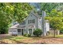 Side view of this two-story home with a well-maintained yard, featuring a charming covered porch and a two-car garage at 802 Bluff Pl, Woodstock, GA 30188