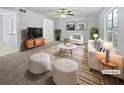Staged living room featuring a comfortable sofa, stylish chairs, a modern rug, and ample natural light from large windows at 978 Monopoly Dr, Lawrenceville, GA 30046