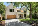 Elegant two-story home featuring a brick facade, wooden garage doors, manicured lawn, and inviting curb appeal at 2609 Dogwood Terrace Ne, Atlanta, GA 30319