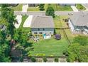 Aerial view of a fully fenced backyard, boasting a lush lawn, patio seating, and a trampoline at 3420 Pleasant Springs Dr, Cumming, GA 30028