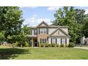 Charming two-story home with stone accents, landscaped lawn, and mature trees at 3420 Pleasant Springs Dr, Cumming, GA 30028