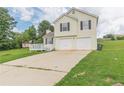 Charming two-story home with a two-car garage, green lawn, and a small deck at 341 Brookside Dr, Mcdonough, GA 30253