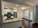 Well-lit eat-in kitchen featuring granite countertops, stainless appliances and hardwood floors at 5535 Bright Cross Way, Suwanee, GA 30024