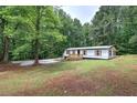 Scenic view of a single-story home with a spacious yard and mature trees at 12208 Buchanan Hwy, Temple, GA 30179