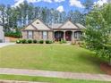 Charming single story home with stone exterior and manicured lawn features covered front porch at 6460 Valley Crossing Way, Cumming, GA 30028