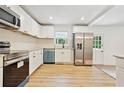 Bright kitchen featuring white cabinets, stainless steel appliances, modern backsplash, and hardwood floors at 383 Oakridge Dr, Cartersville, GA 30121
