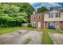 Charming townhome with a brick facade, green lawn, and a private driveway with mature trees at 1696 Hunting Creek Dr Se, Conyers, GA 30013