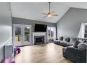 Cozy living room with a fireplace, vaulted ceiling, and access to a deck through French doors at 4905 Martin Farms Dr, Powder Springs, GA 30127