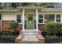 Inviting front entrance with a sage green door, brick accents, and well-maintained landscaping at 839 Cardova Ne Dr, Atlanta, GA 30324