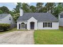 Charming single-story home with a well-manicured lawn, black shutters, and a classic gray front door at 3530 Boulder Cir, Ellenwood, GA 30294