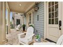 Inviting covered front porch featuring comfortable seating, stylish decor, and a welcoming ambiance at 105 Cumming St, Alpharetta, GA 30009