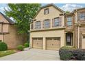 Lovely brick townhome featuring a two-car garage, front entrance, and mature landscaping at 1636 Caswell Pkwy, Marietta, GA 30060