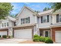 Inviting townhome with gray siding, brick details, a two-car garage, and a welcoming front porch at 461 Mountain View Ln, Woodstock, GA 30188