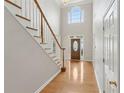 Bright foyer featuring hardwood floors, a wooden staircase, and a front door with glass panels at 1250 Parkview Nw Ln, Kennesaw, GA 30152