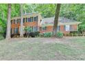 Two-story brick home with manicured landscaping, complemented by dark green shutters on a sunny day at 1592 Walkway Ct, Lilburn, GA 30047