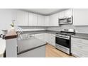 Bright kitchen with sleek stainless steel appliances, ample counter space, and modern white cabinetry at 40 Queensland Ln, Covington, GA 30016