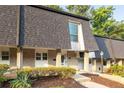Inviting townhome exterior featuring a brick facade and a well-maintained lawn with attractive landscaping at 5170 Chemin De Vie Ne, Sandy Springs, GA 30342