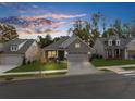 A beautiful home is showcased at sunset with a perfectly manicured lawn at 218 Floral Valley Dr, Woodstock, GA 30188
