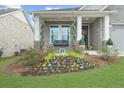 Charming front yard with vibrant flower beds, a porch swing, and stone accents at 218 Floral Valley Dr, Woodstock, GA 30188
