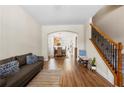 Inviting living room with hardwood floors, an archway leading to the kitchen, and a staircase with iron railings at 240 Daisy Cir, Mcdonough, GA 30252
