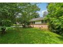 Spacious side yard with lush green grass and mature trees providing shade and privacy to the property at 2880 Shallowford Rd, Chamblee, GA 30341