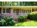 Brick home showcasing a charming front porch and well-manicured landscaping at 2518 Foster Ridge Ne Ct, Atlanta, GA 30345