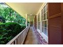 Covered front porch featuring brick accents and a white railing overlooking the lush greenery at 2518 Foster Ridge Ne Ct, Atlanta, GA 30345