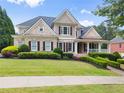 Beautiful two-story home with manicured lawn, shrubbery, and classic architectural details at 4526 Meadow Club Dr, Suwanee, GA 30024