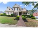 Attractive two-story home featuring a brick path, lush lawn, and professionally landscaped front yard at 4526 Meadow Club Dr, Suwanee, GA 30024