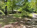 View of the driveway leading up to the house and partially obscured by trees at 4701 Cleveland Rd, Lithonia, GA 30038