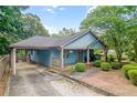 Lovely blue home with covered parking and a cozy front porch, nestled among mature trees at 730 Brownwood Se Ave, Atlanta, GA 30316