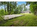 Spacious backyard featuring a large concrete slab and lush greenery, perfect for outdoor activities at 924 Sweetwater Cir, Lawrenceville, GA 30044