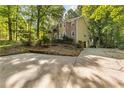 View of exterior and parking area showing mature trees and landscaping at 119 Castlewood Rd, Tyrone, GA 30290